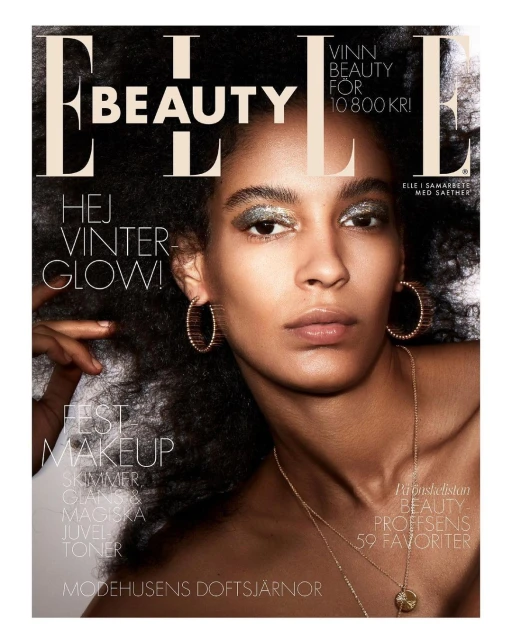 Elle Beauty cover featuring an adult female with glitter eyeshadow, gold jewelry, and natural dark hair. Magazine cover advertises winter beauty.