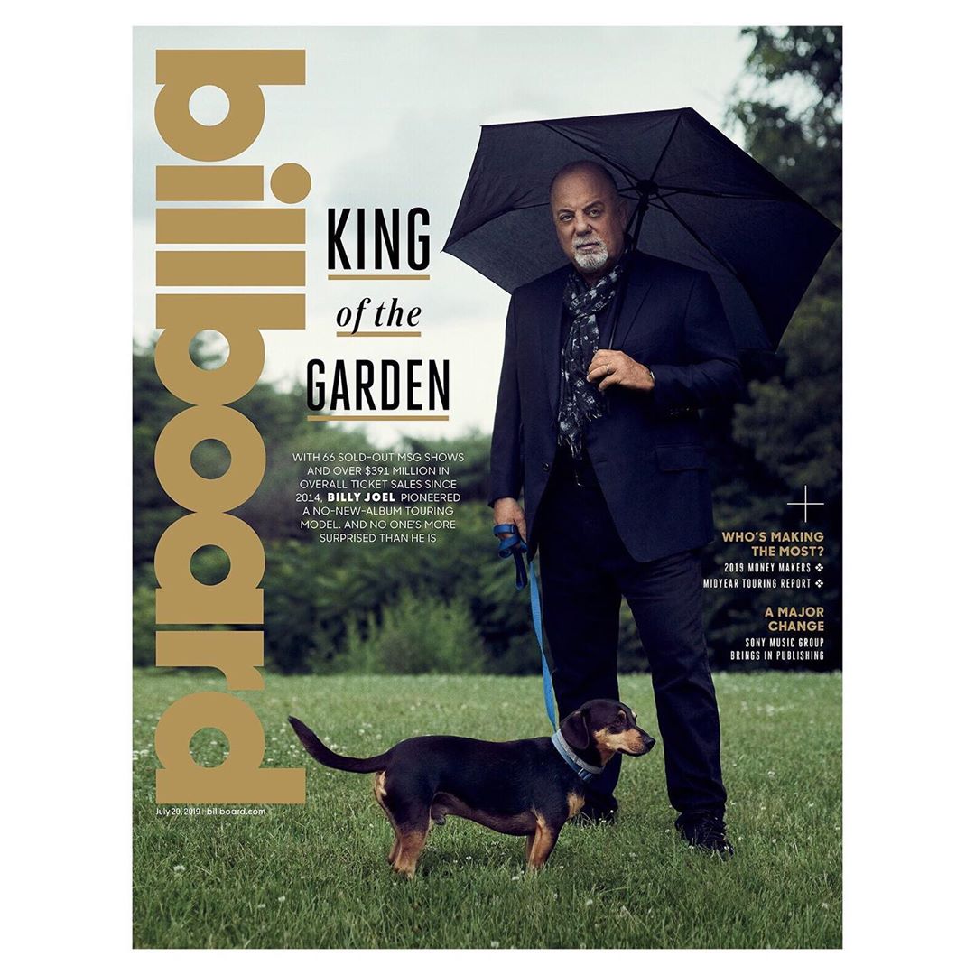 Billboard magazine cover featuring Billy Joel standing in a grassy field with his dog, holding an umbrella, wearing a dark suit.