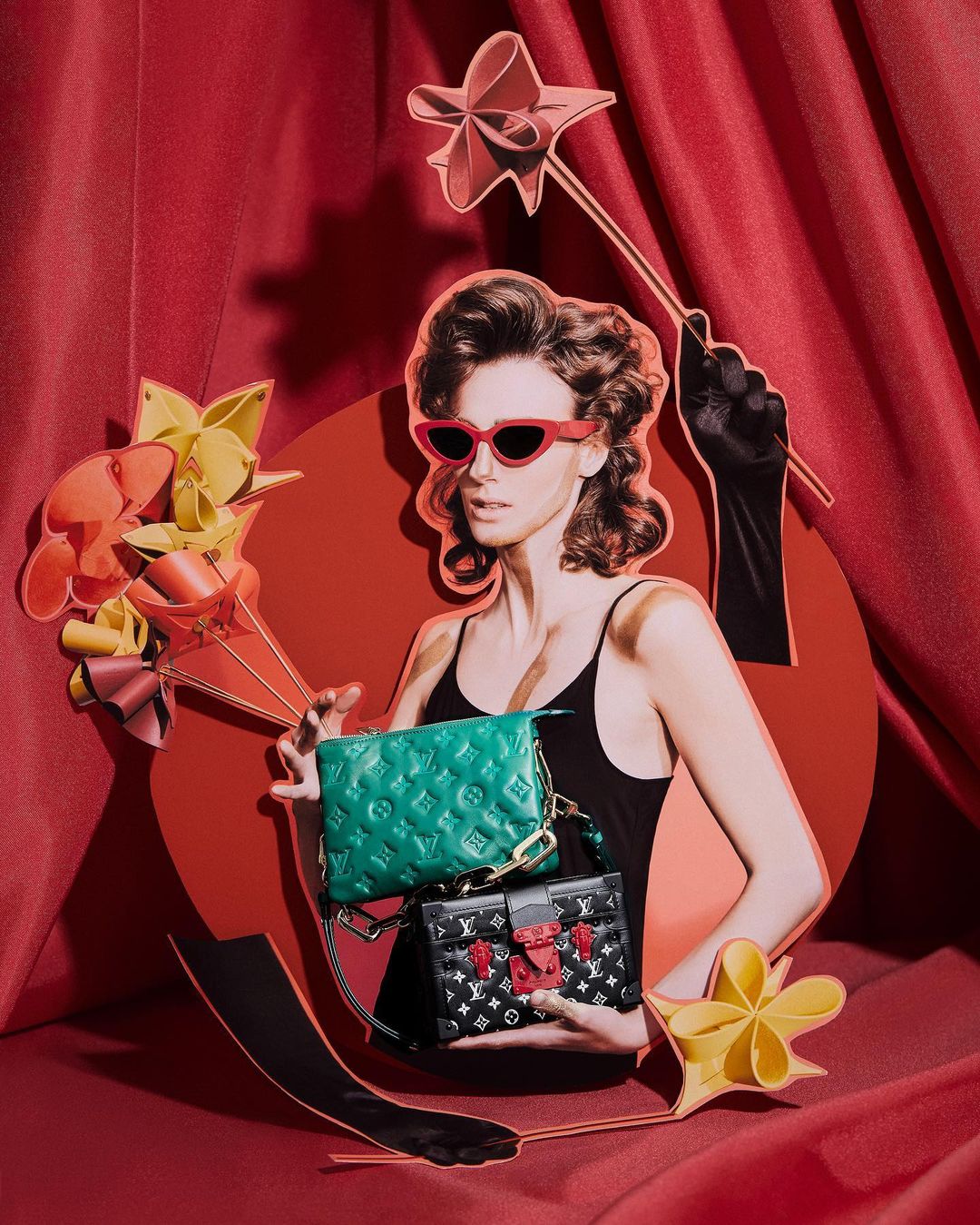 Fashion editorial image of a woman with two luxury handbags, styled with gloves and vintage sunglasses against a red backdrop.