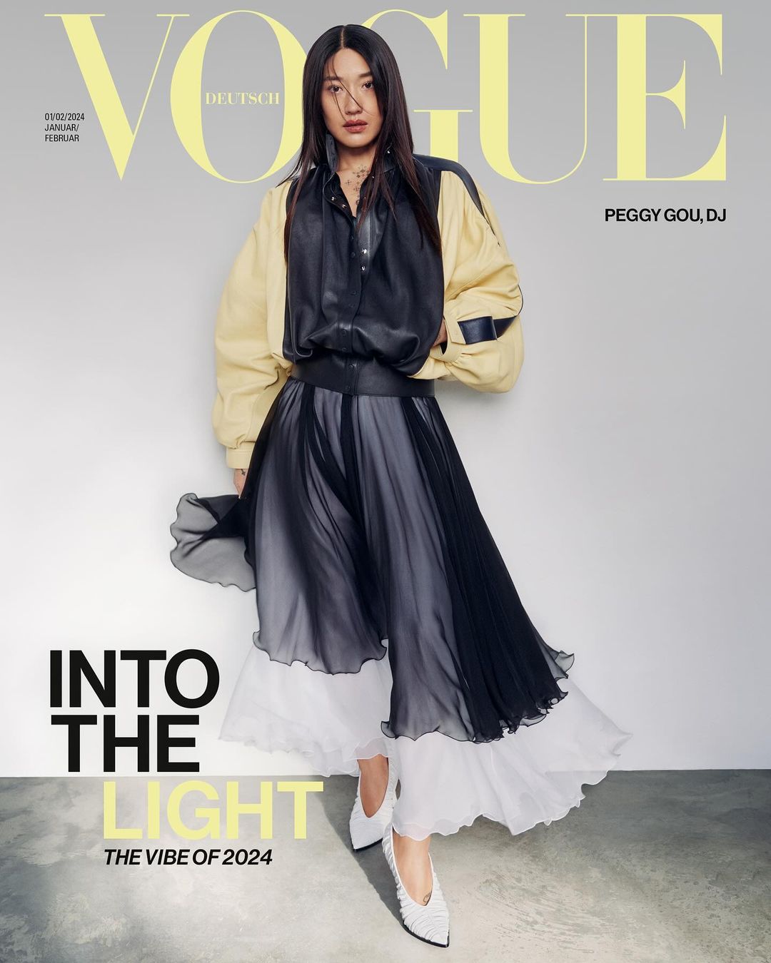 Vogue Deutsch cover featuring an Asian woman in a black and beige outfit, full body pose against a grey background, with 'Vogue' text overlay.
