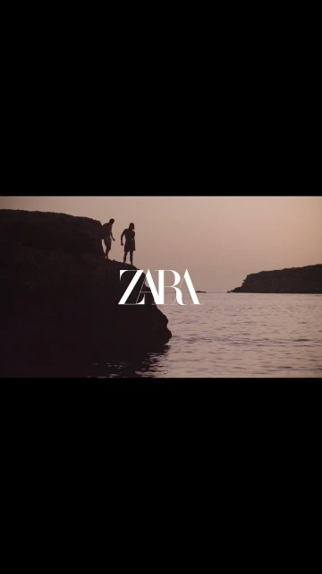 Two silhouetted figures stand on a rock overlooking a body of water, with the ZARA logo prominently displayed in the foreground.