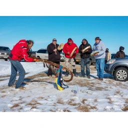 Group of men playing traditional drums outdoors in a snowy landscape by Mitch Epstein
