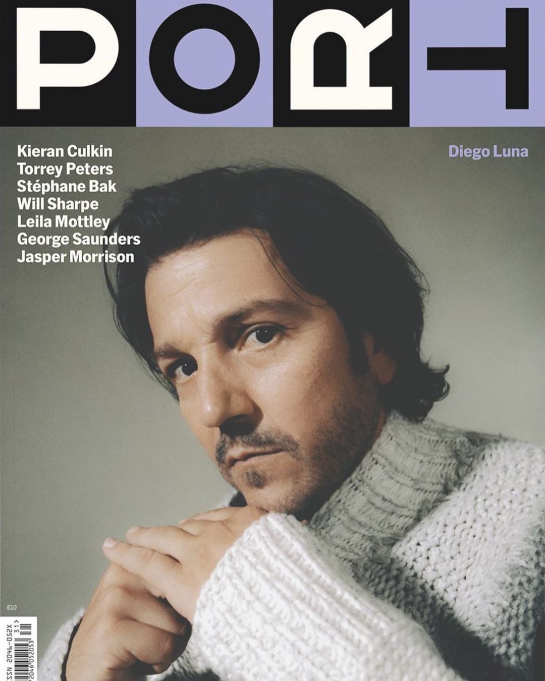 Magazine cover featuring Diego Luna in a grey sweater against a light grey background, with magazine text and other names overlaid.