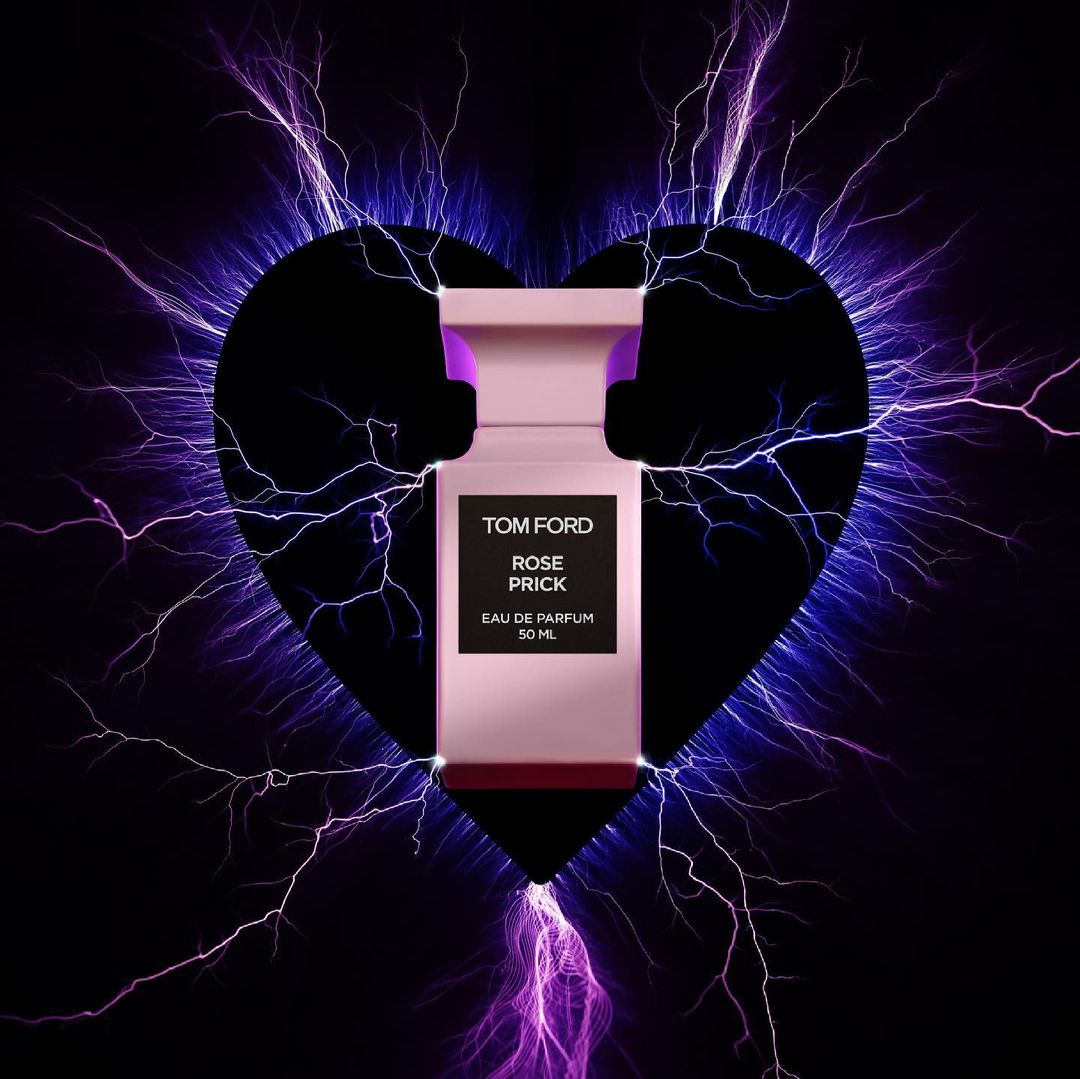 Close-up of Tom Ford Rose Prick perfume bottle, pink and black, with electrical discharge graphic and heart shape against a black background.
