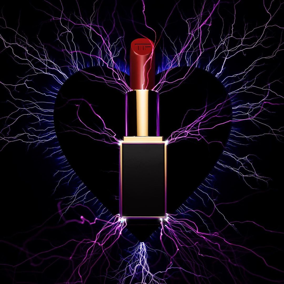 Tom Ford lipstick standing vertically against a black background with purple and blue lightning effects