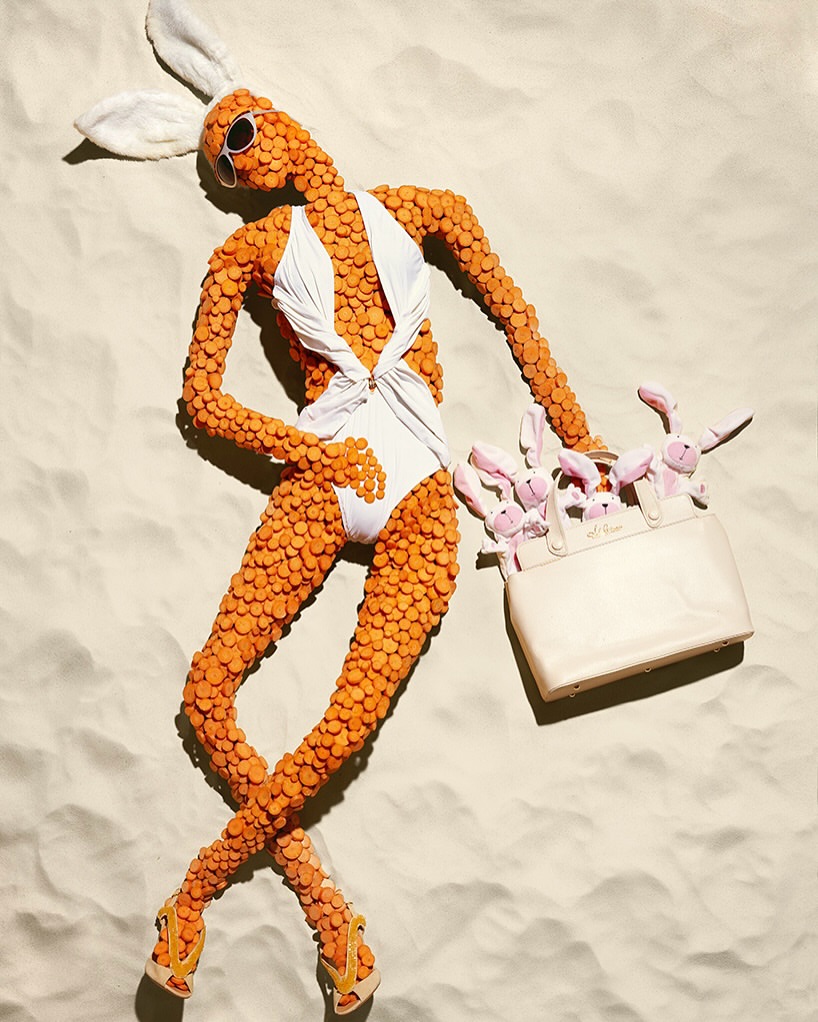 Conceptual fashion shot of a woman made of orange slices in a white swimsuit, sunglasses, and bunny ears, lying on a textured surface.