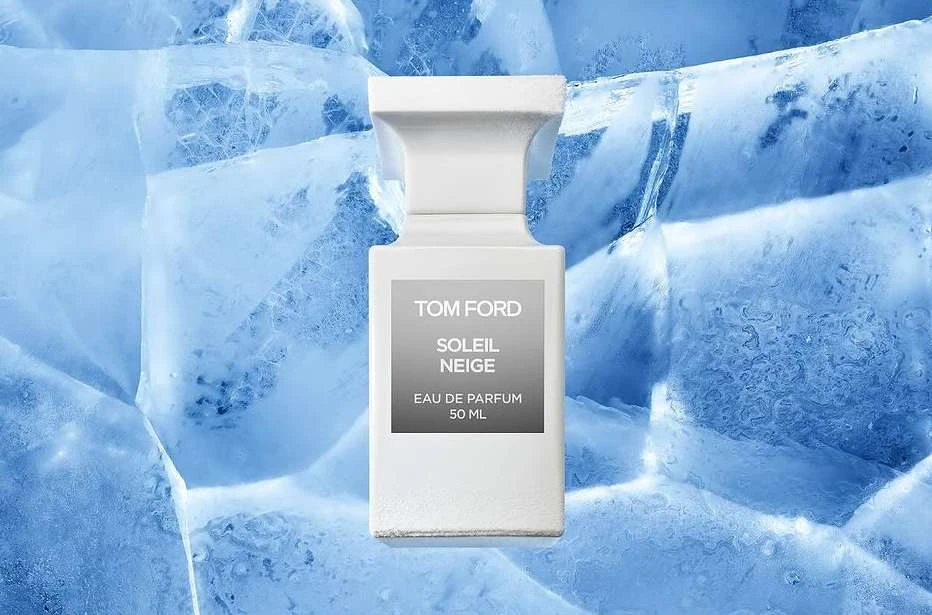 White Tom Ford Soleil Neige perfume bottle set against a blue ice background, evoking a cool and luxurious fragrance experience.