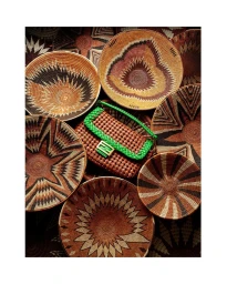 A brown woven handbag with a bright green strap surrounded by multiple intricately patterned woven bowls.