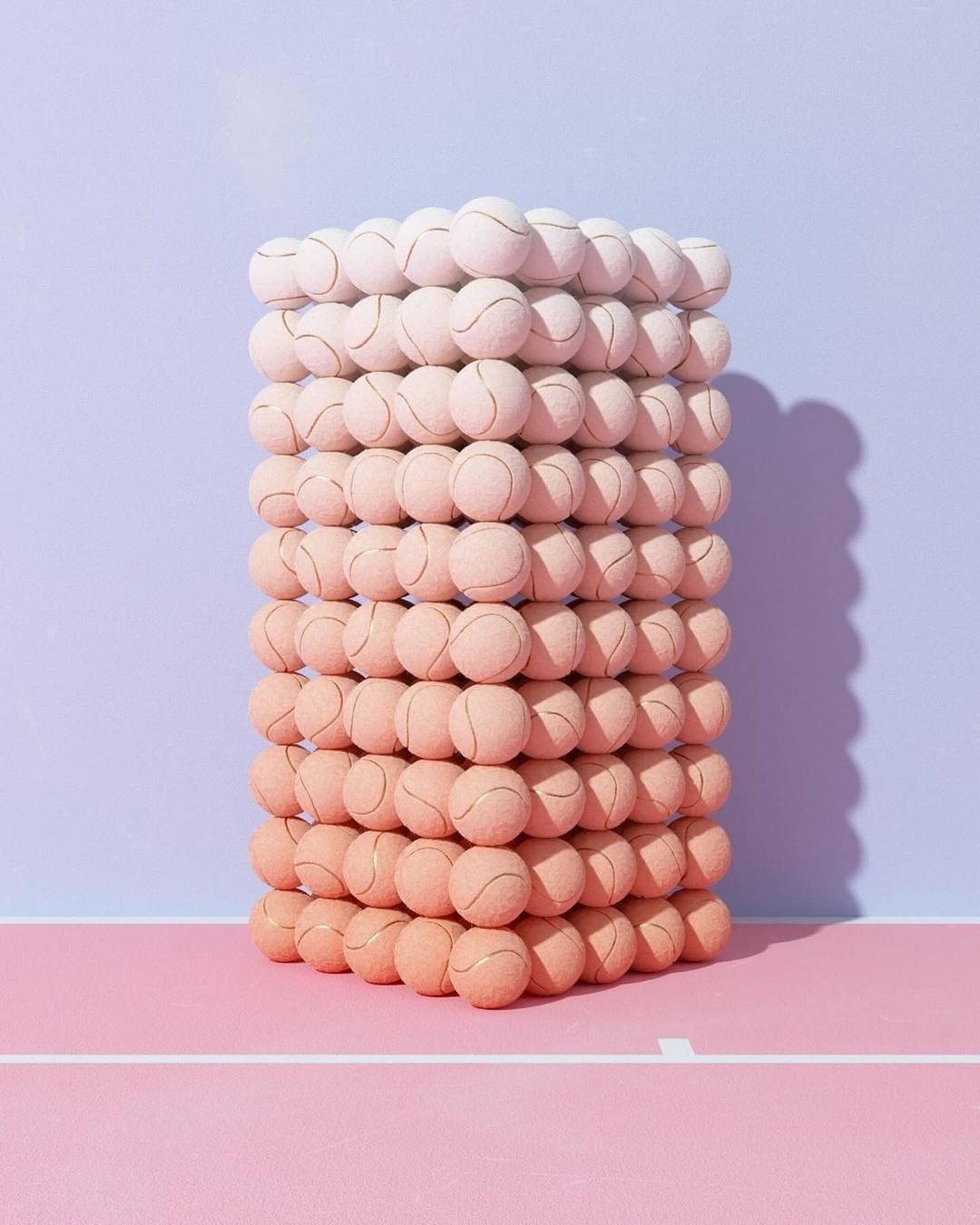 Stacked tennis balls create an unusual tower effect with color gradations in a whimsical studio shot against a pink and blue background.