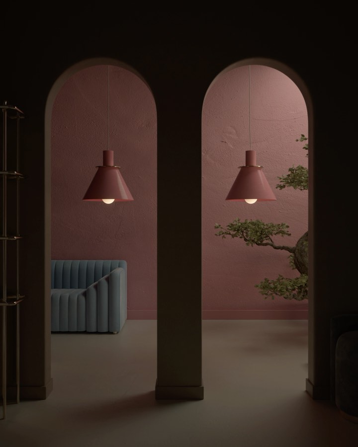 Interior view through two arched openings reveals hanging pendant lights, modern blue sofa, and an indoor bonsai tree against a pink wall.