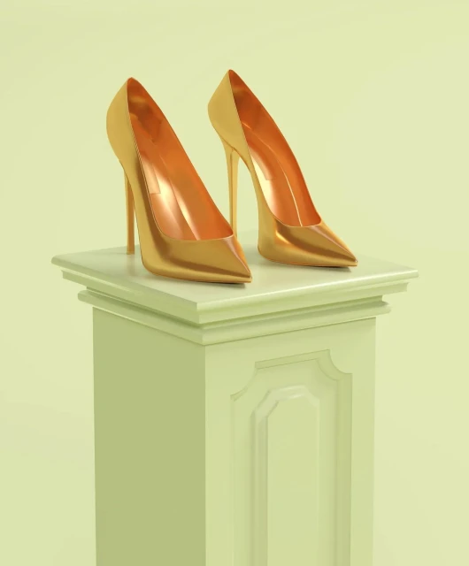 Pair of gold-colored, high-heeled shoes staged on a light green decorative column against a light green backdrop in a studio setting.
