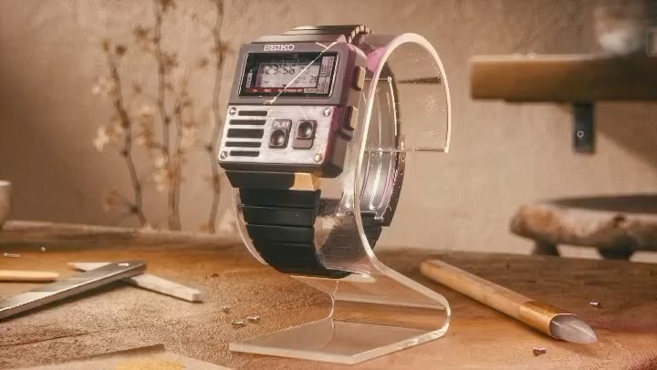 Close-up of a vintage Seiko watch with a retro-futuristic design on a clear display stand, showcasing a blend of old and new aesthetics.