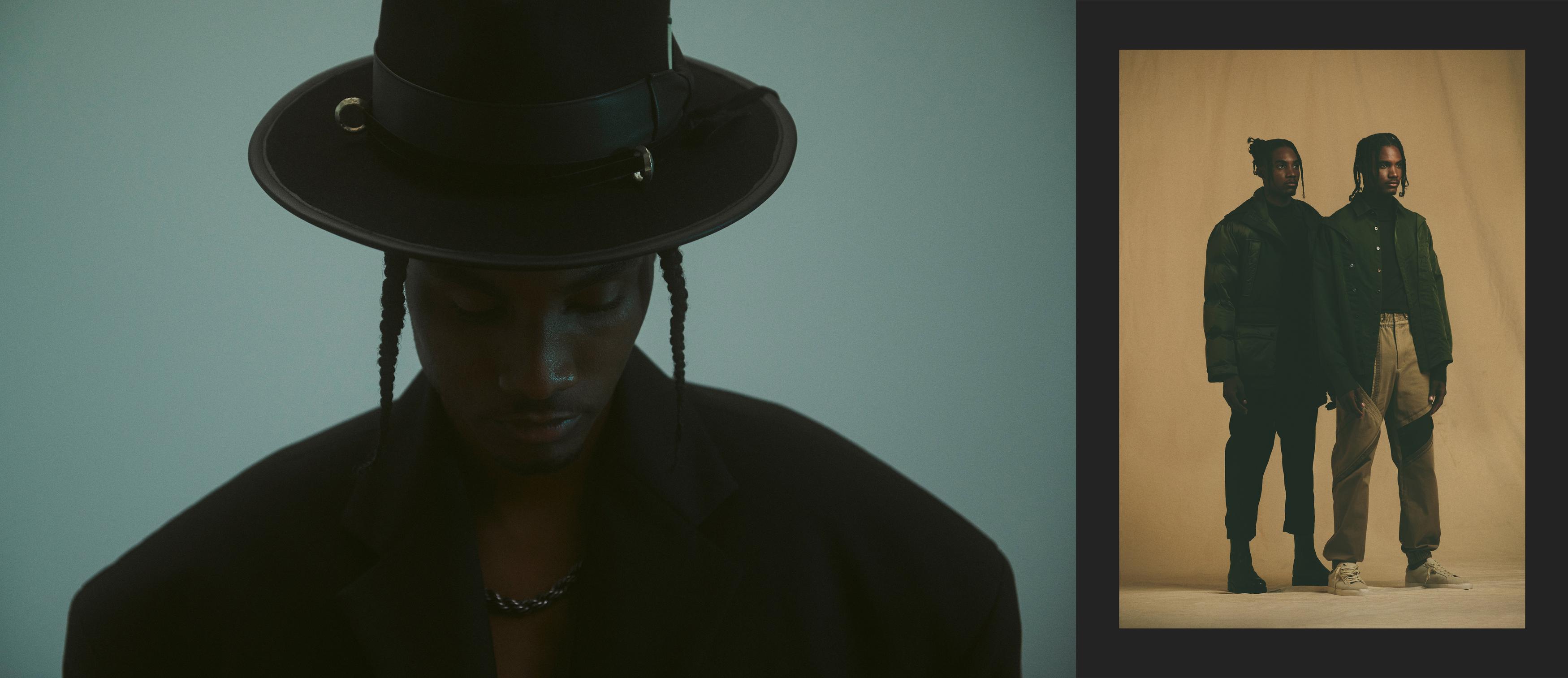 Two African American men pose in an indoor studio wearing hats, jackets, pants, and necklaces against teal and tan backdrops.