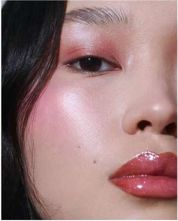 Close-up beauty portrait of a woman featuring glossy pink lips, flushed cheeks, and shimmering eyeshadow by Monika Lis