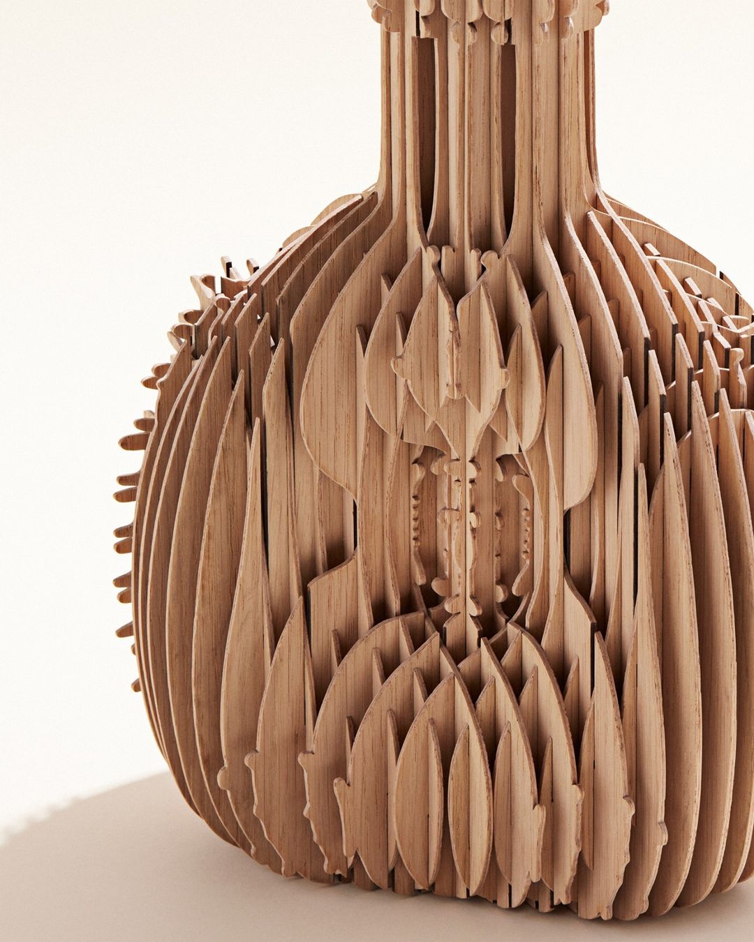 Close-up of a uniquely designed light brown wooden vase made up of stacked layers against a bright white background in a studio setting.