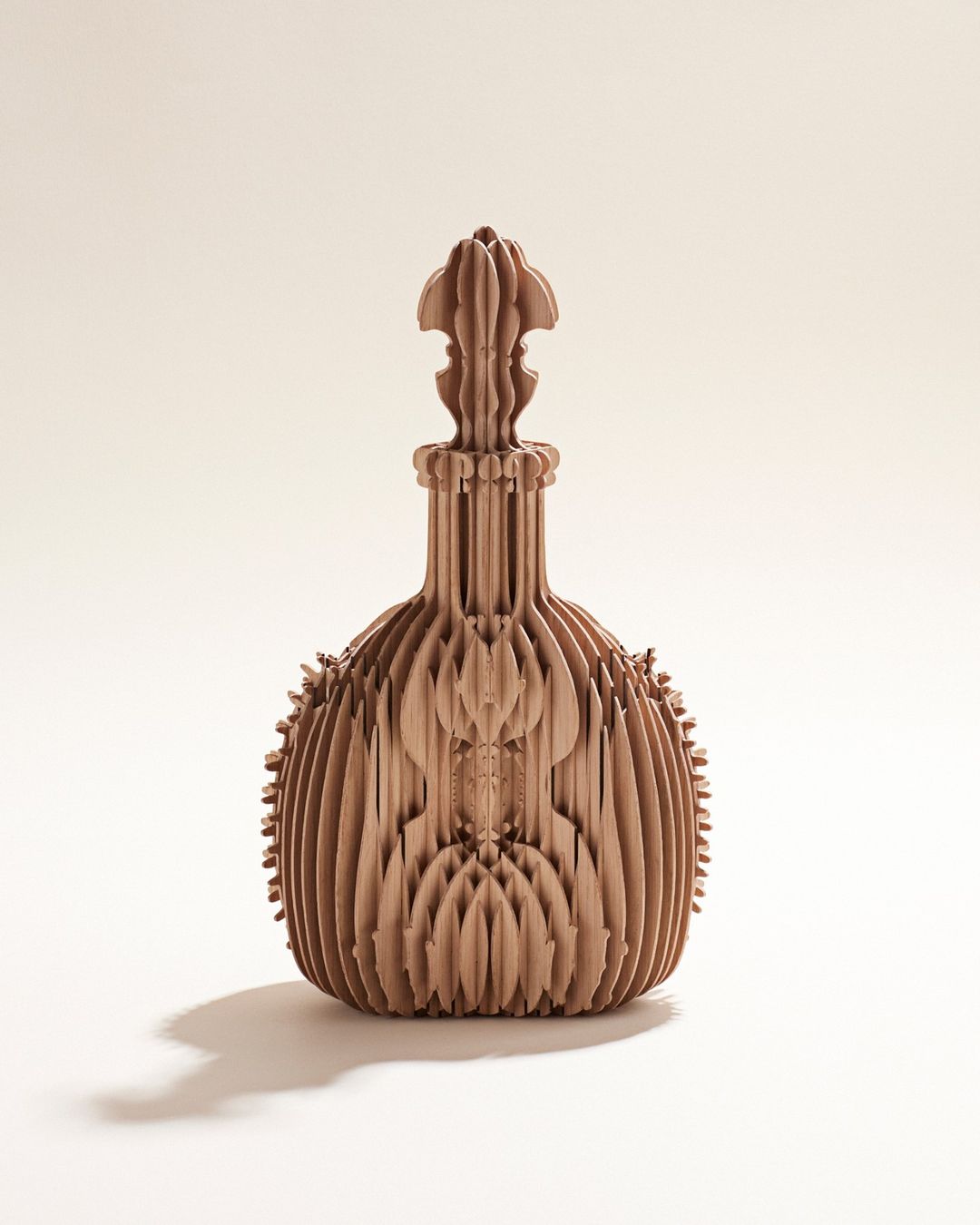 Intricate laser-cut wood bottle art piece with layered contours on a bright background creating a decorative modern design.