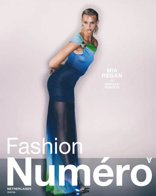Fashion editorial shot of a blonde adult woman posing in a blue ombre dress on a gradient background for Numero Netherlands magazine.