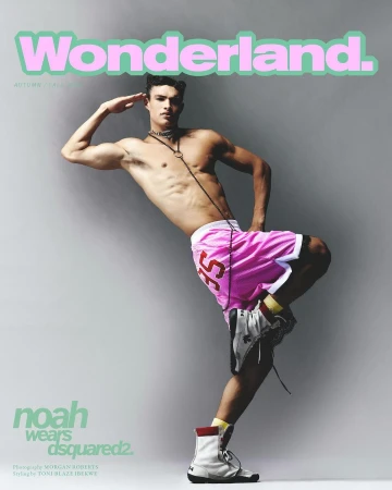 Magazine cover featuring a shirtless male model in pink shorts, posing in front of a gray background. He is wearing high top sneakers.