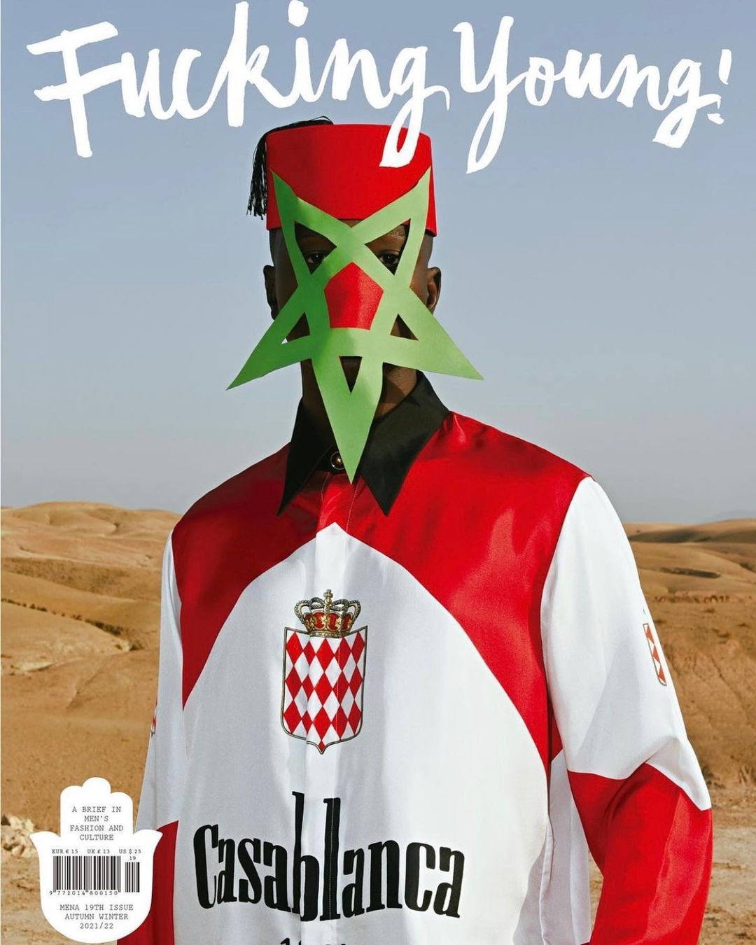 Magazine cover featuring a person wearing traditional Moroccan clothing and a geometric mask, set against a desert landscape.