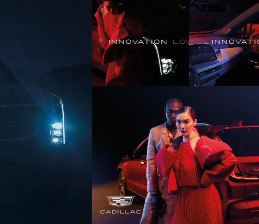 Automotive advertisement featuring a red Cadillac SUV, an adult male, and an adult female posing in front of the vehicle.