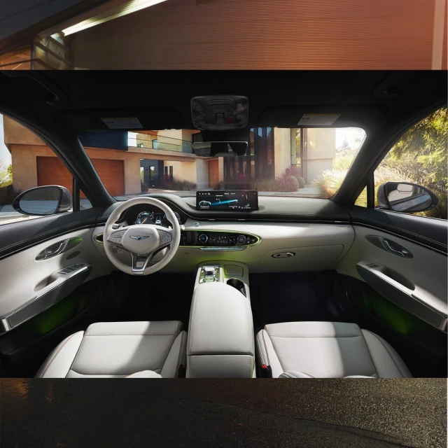 Car interior shot featuring a white and grey color scheme, showcasing the dashboard, seats, and center console, with a home exterior visible.