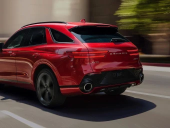 Red luxury SUV driving on a city street with motion blur background captured by photographer Mp Curtet.