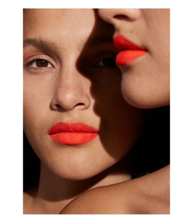 Close-up portrait of two women wearing vibrant red lipstick with harsh shadow cutting across faces