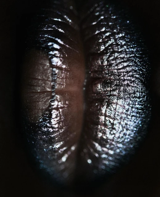 Close-up studio shot of a glossy, textured, dark brown surface with a deep crevice, illuminated by dramatic lighting.