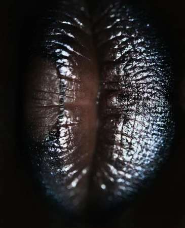 Close-up studio shot of a glossy, textured, dark brown surface with a deep crevice, illuminated by dramatic lighting.