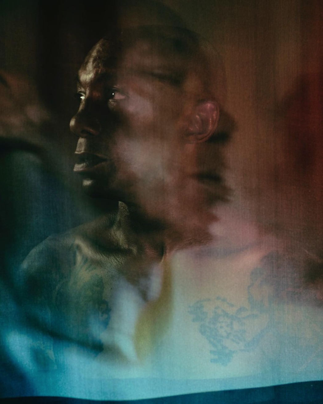 Artistic portrait of an adult male with dark skin and short hair, featuring blurred motion effect, vibrant colors and unique visual textures.