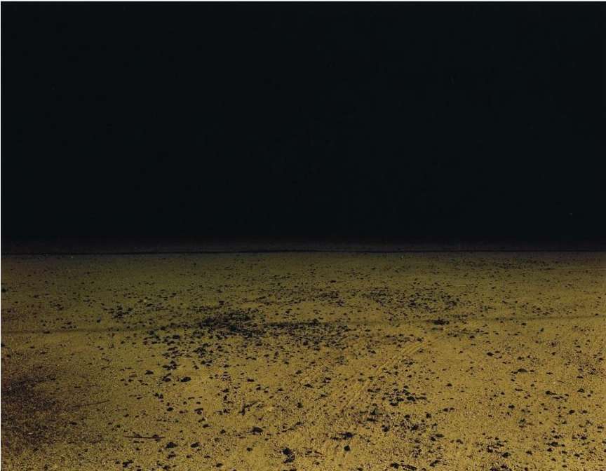 Abstract landscape with a dark sky over a textured, golden field, creating a sense of depth and desolation in an outdoor scene.