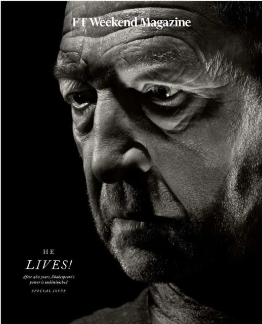Striking black and white close-up portrait of an older adult male, with the top of a magazine visible in the composition.