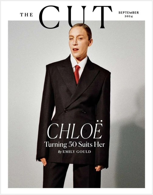 Chloe Sevigny on the cover of The Cut magazine, September 2024 issue. She is wearing a black oversized suit and a red tie.