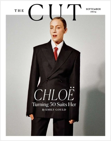 Chloe Sevigny on the cover of The Cut magazine, September 2024 issue. She is wearing a black oversized suit and a red tie.