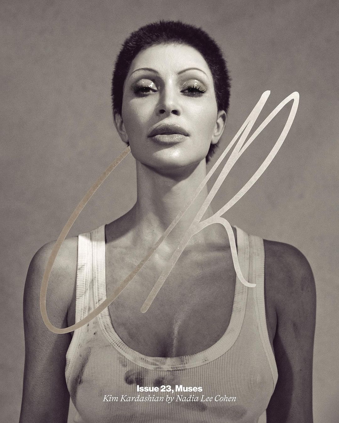 Sepia portrait of Kim Kardashian on a magazine cover, wearing a white tank top and with short hair, against a neutral backdrop.