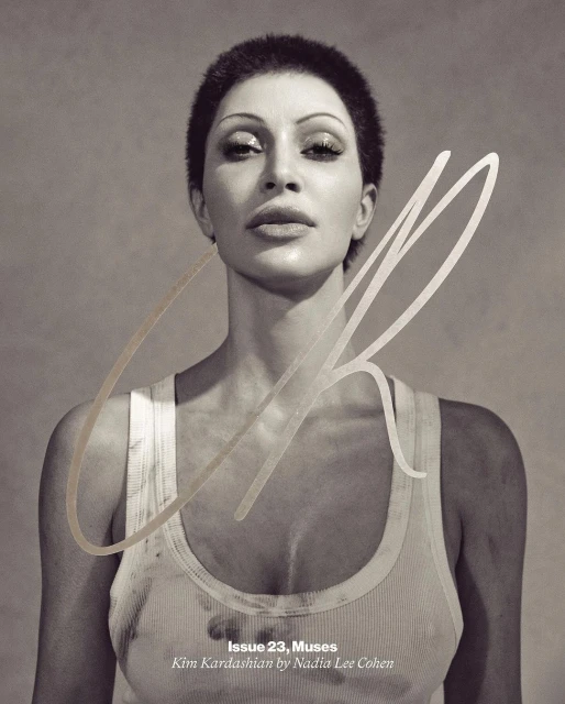 Sepia portrait of Kim Kardashian on a magazine cover, wearing a white tank top and with short hair, against a neutral backdrop.