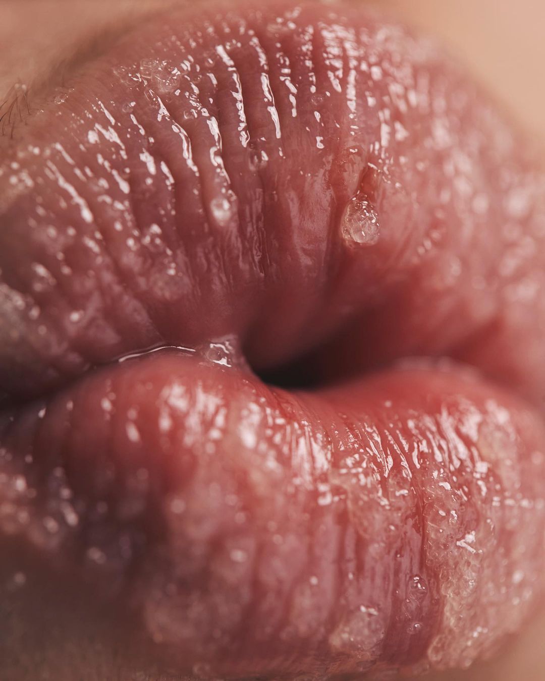 Close-up studio shot of human lips, highlighting texture and details in a beauty or healthcare context. Focus on the lip surface.