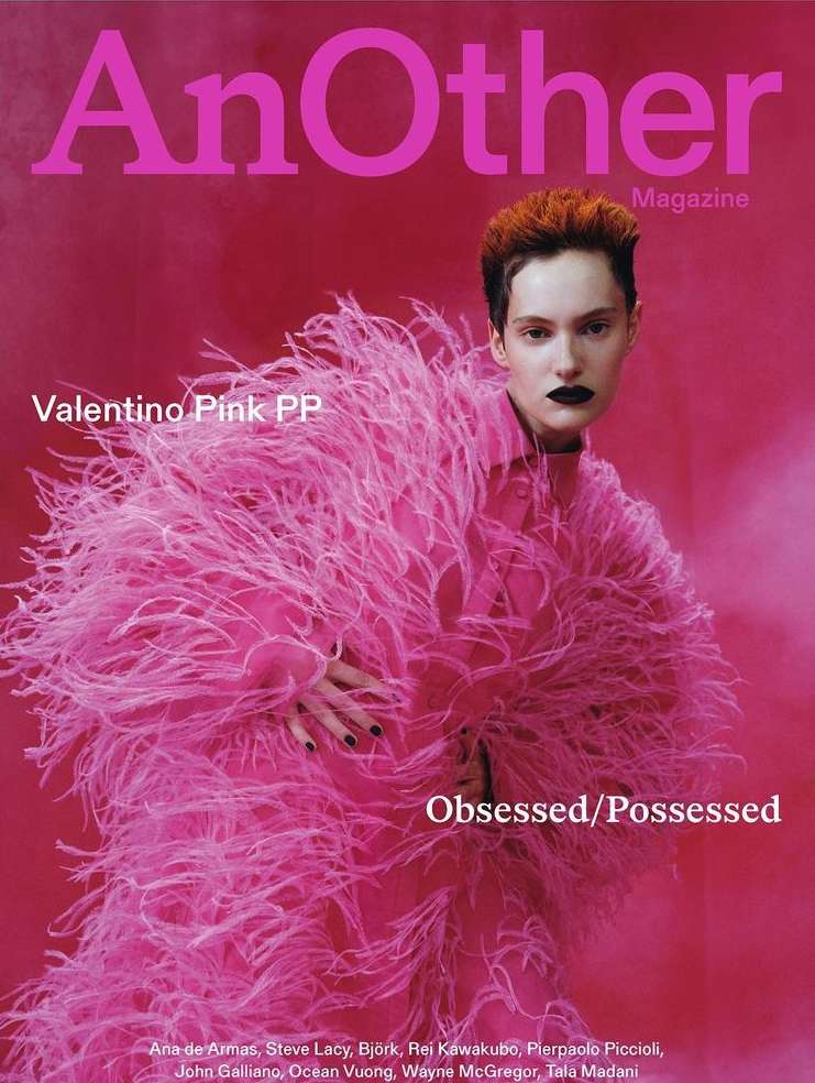 Magazine cover featuring a woman with short red hair wearing a pink feathered coat against a matching pink background. Cover text visible.