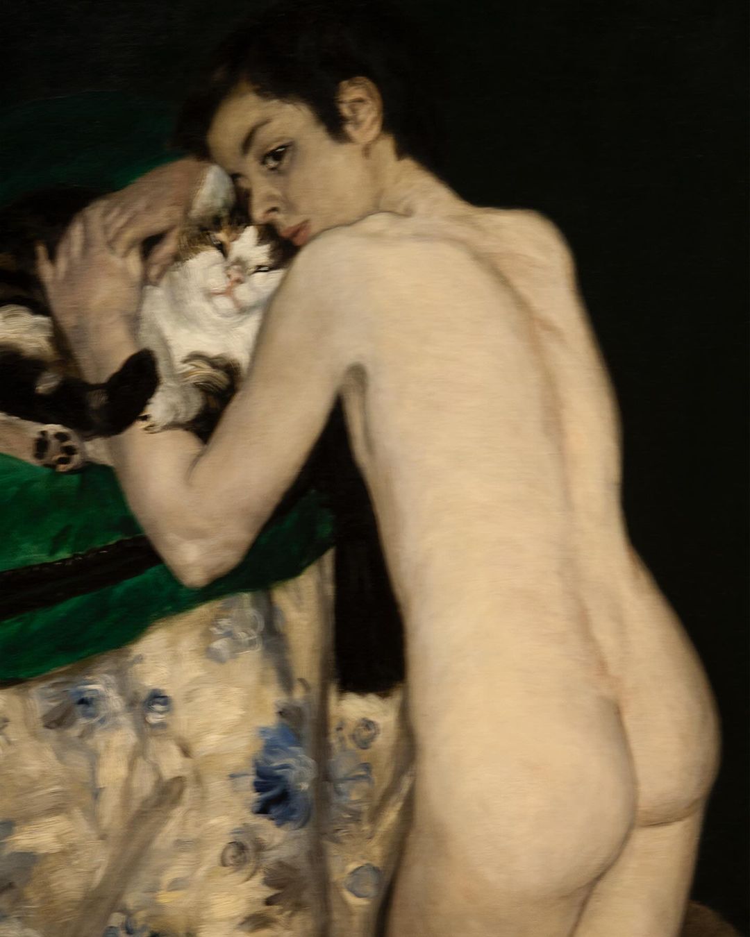 Oil painting of nude person holding a calico cat, resting on a floral upholstered surface, against a dark background in fine art style.