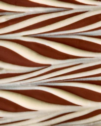 Macro shot of swirled white and dark chocolate with a glossy textured surface pattern