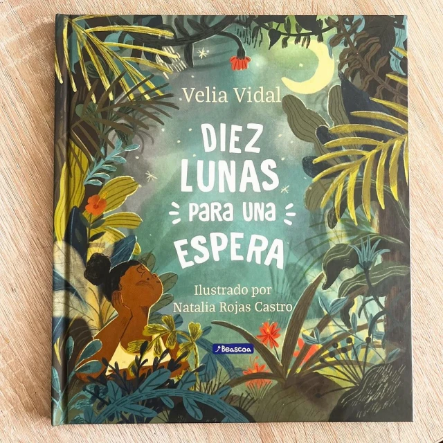 Book cover illustration of 'Diez Lunas Para Una Espera' by Velia Vidal, featuring a young girl in a jungle setting with vibrant greenery and a night sky.