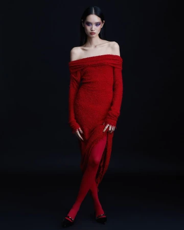 Model wearing a red off-the-shoulder dress and matching red tights against a dark background in Paris by Natasja Fourie.
