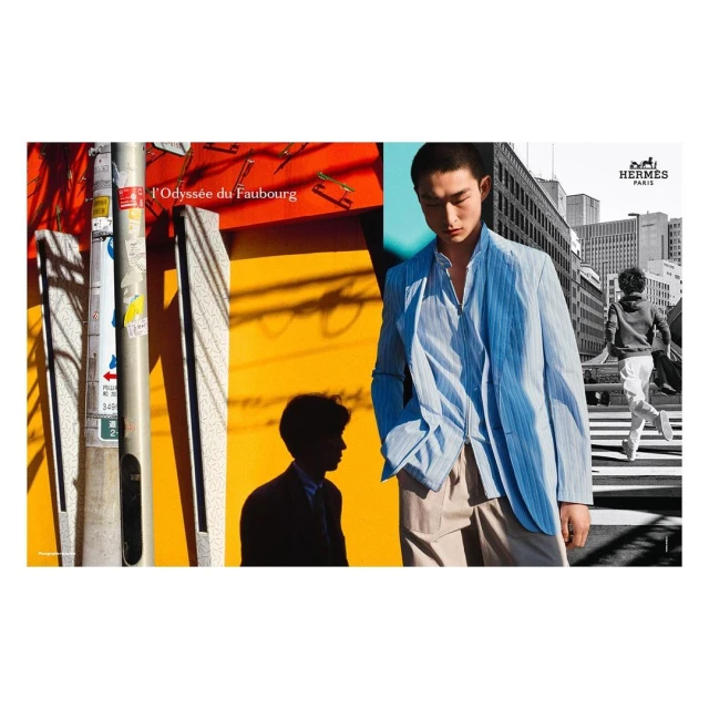 Asian male model in a blue striped jacket and khaki pants stands in front of a colorful urban backdrop for a fashion editorial.