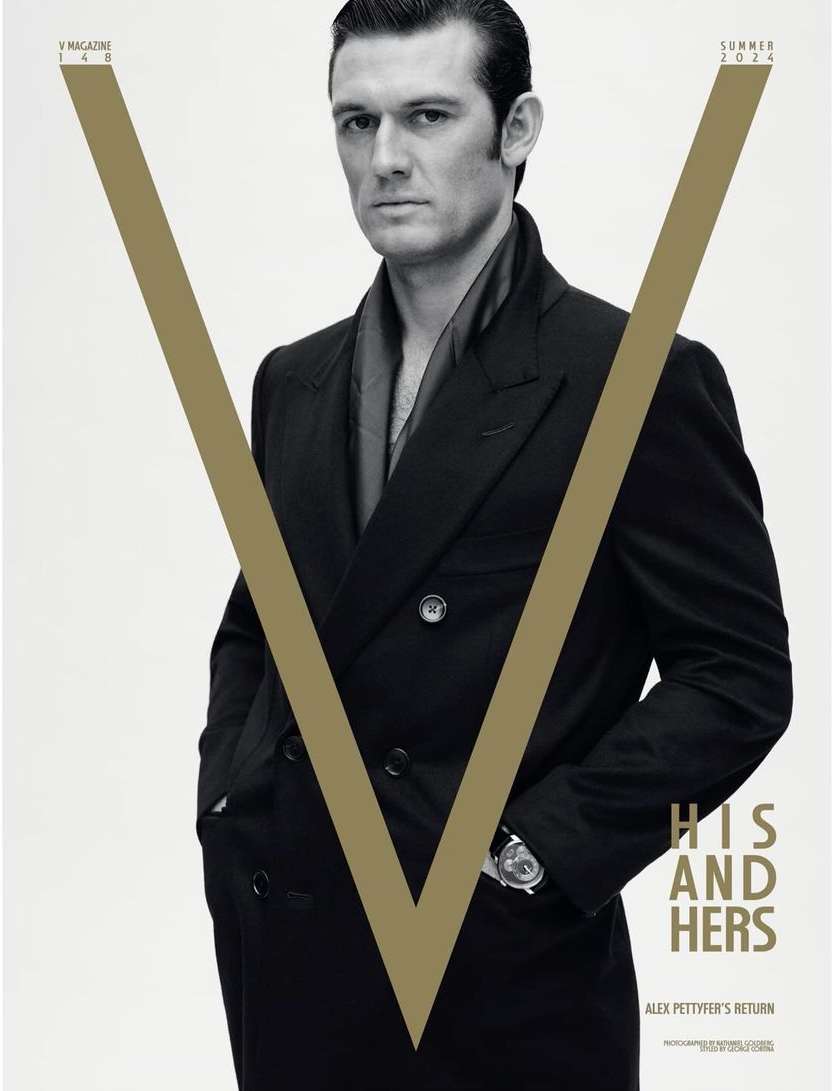 Magazine cover featuring a portrait of a man in a dark overcoat against a bright background with a large V graphic element.