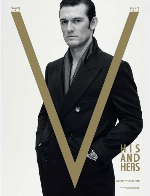 Magazine cover featuring a portrait of a man in a dark overcoat against a bright background with a large V graphic element.