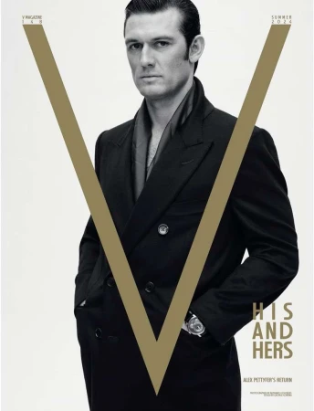 Magazine cover featuring a portrait of a man in a dark overcoat against a bright background with a large V graphic element.