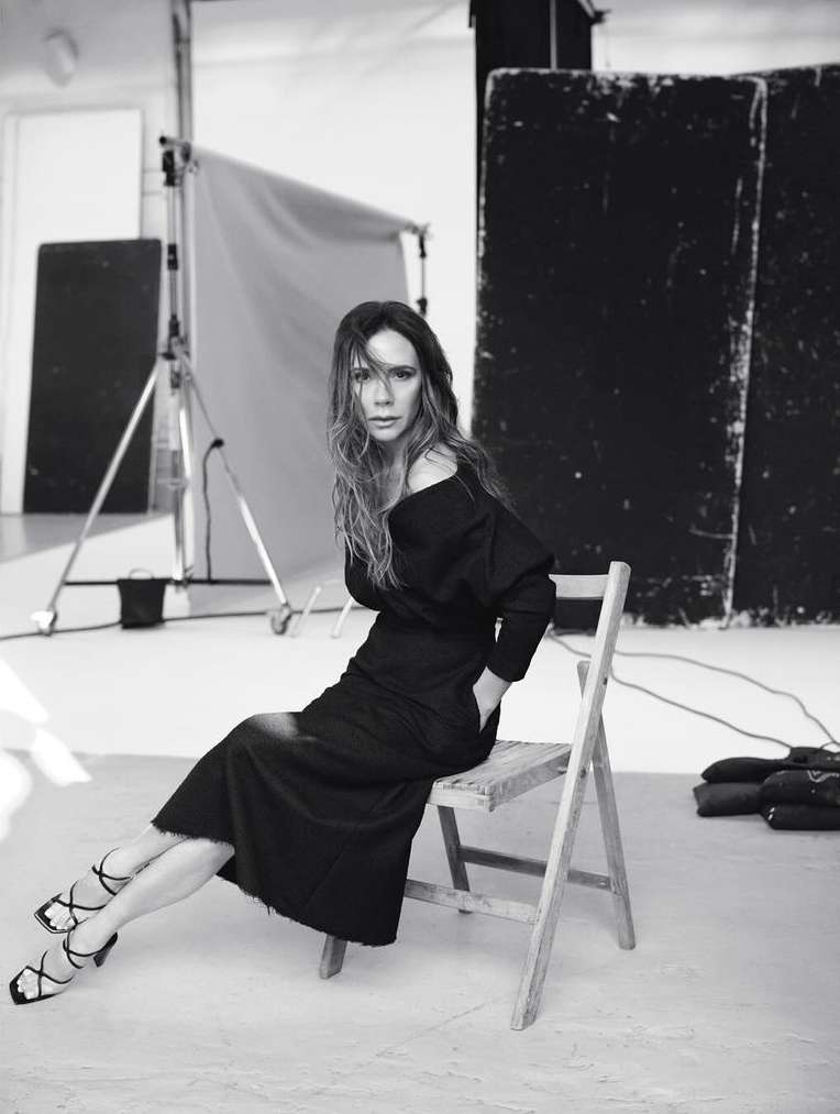 Victoria Beckham seated on a wooden folding chair in a studio by Nathaniel Goldberg