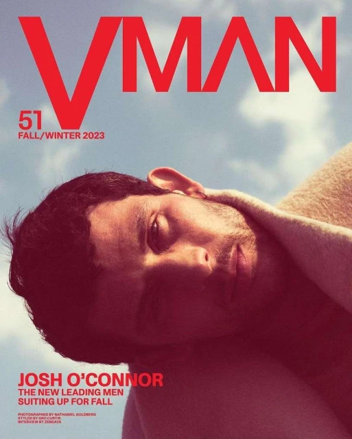 VMAN magazine cover featuring Josh O'Connor against a blue sky with clouds. The cover text is in red, promoting the Fall/Winter 2023 issue.