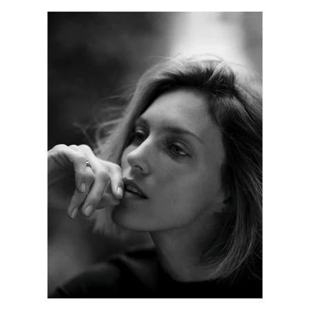 Close up monochrome portrait of a woman with short hair resting her hand near her lips by Nathaniel Goldberg