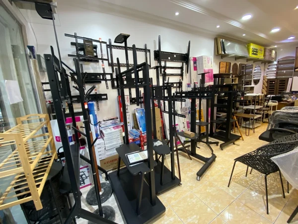 Interior showroom in Riyadh displaying black metal TV stands and mounts with tiled floors